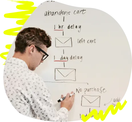 Mann skizziert einen Prozessablauf auf einem Whiteboard